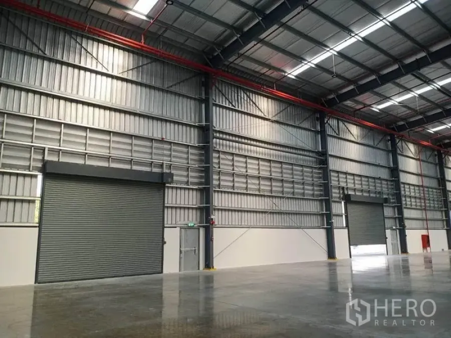โรงงาน ให้เช่าในMueang Rayong, Rayong - ภายในโรงงานเพดานสูง โครงสร้างเหล็ก หลังคาโปร่งแสง มีสปริงเกลอร์และประตูม้วนขนาดใหญ่