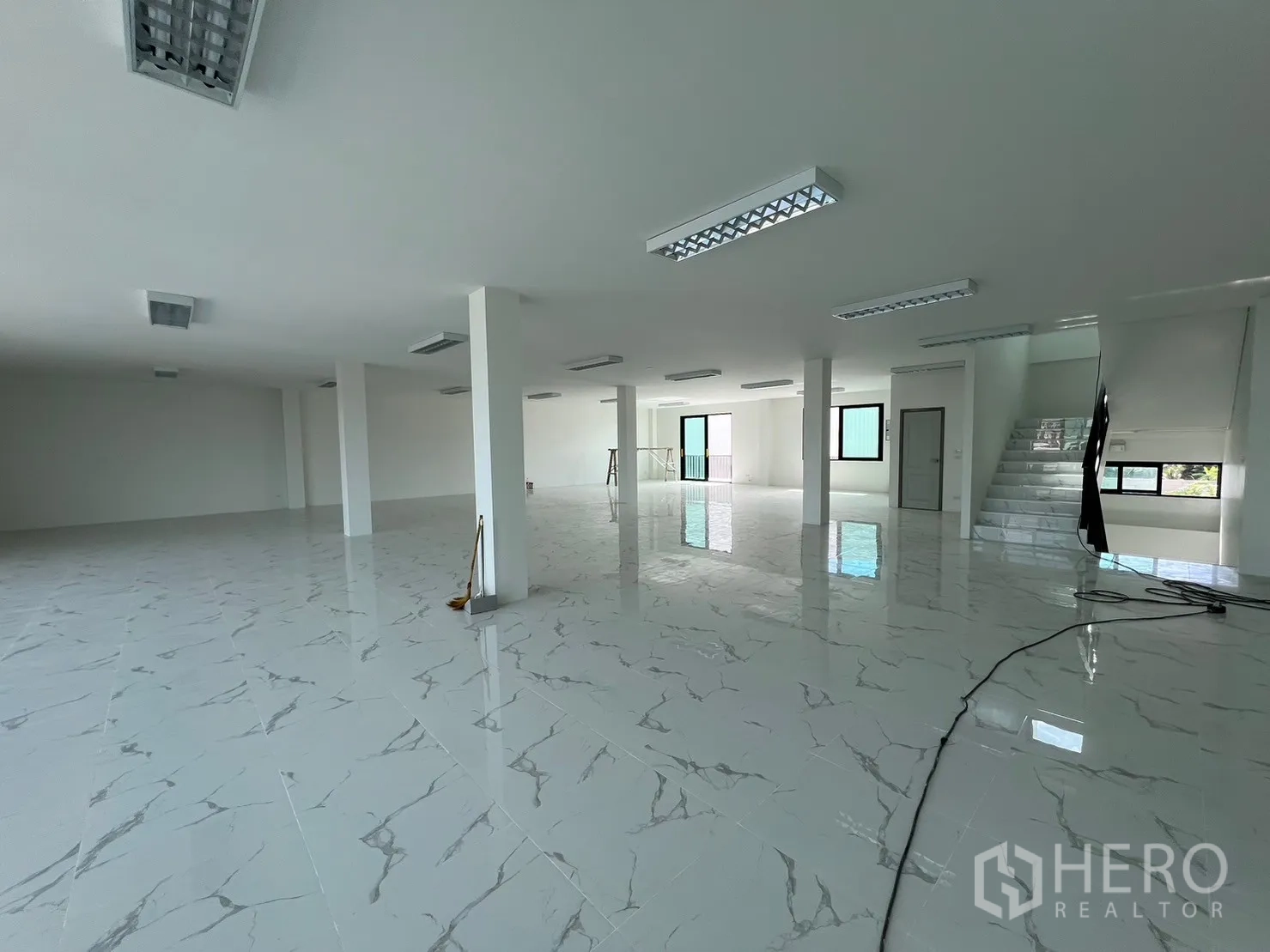 Warehouse for rent in Samut Prakan - Open-plan upper level with tiled floors, columns and recessed lighting panels.