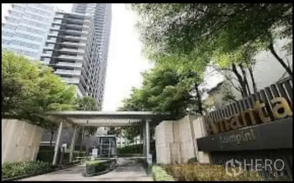 Condominium for rent in Sathon, Bangkok - High-rise condominium entrance with landscaped driveway and security gate.
