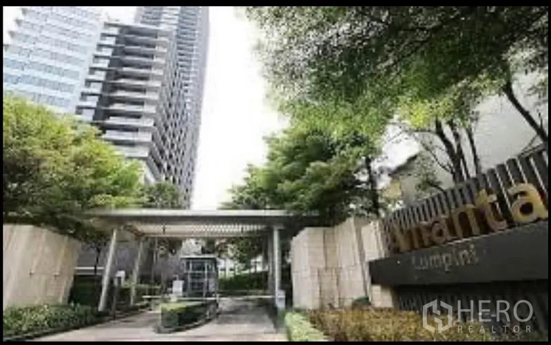 Condominium for rent in Sathon, Bangkok - High-rise condominium entrance with landscaped driveway and security gate.
