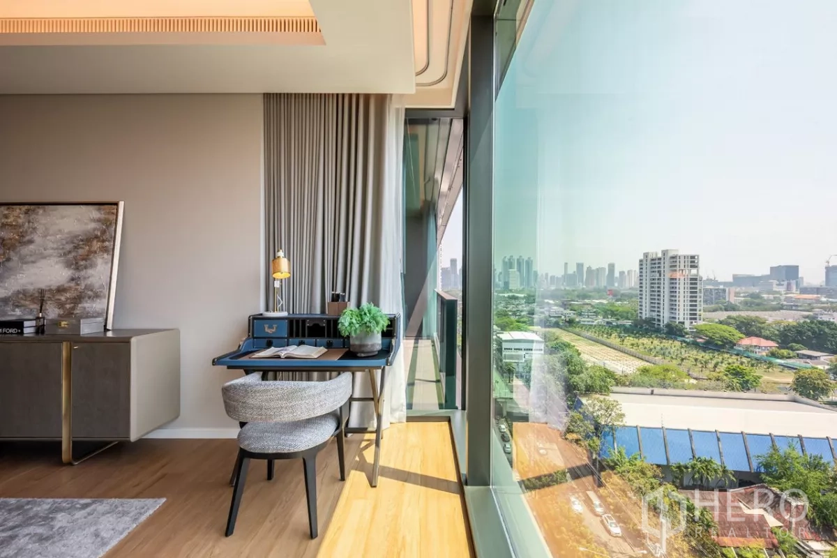 公寓 出租或出售在Pathum Wan, Bangkok - 落地窗旁的书桌角，远眺城市天际线。