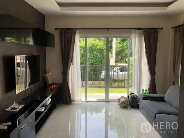 Detached House for rent in Saphan Sung, Bangkok - Bright living room with sliding glass doors, sheer curtains and built-in TV console.