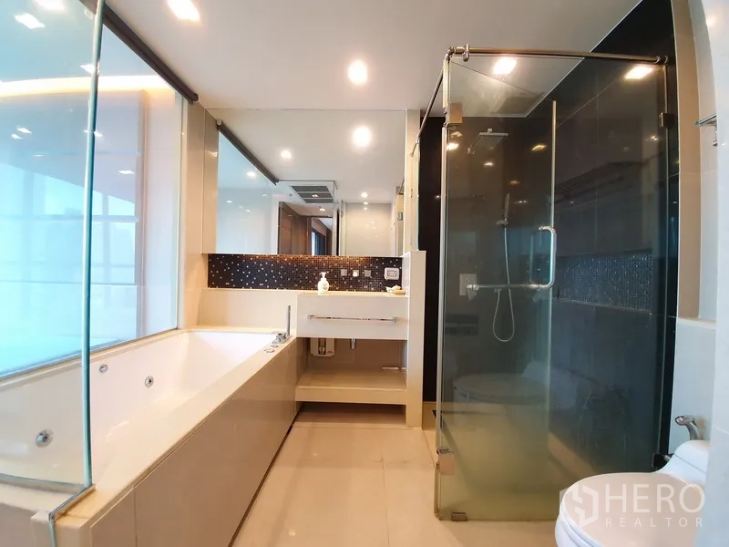 Condominium for rent in Bang Rak, Bangkok - Luxury ensuite bathroom with soaking tub, glass shower, and vanity with large mirror.