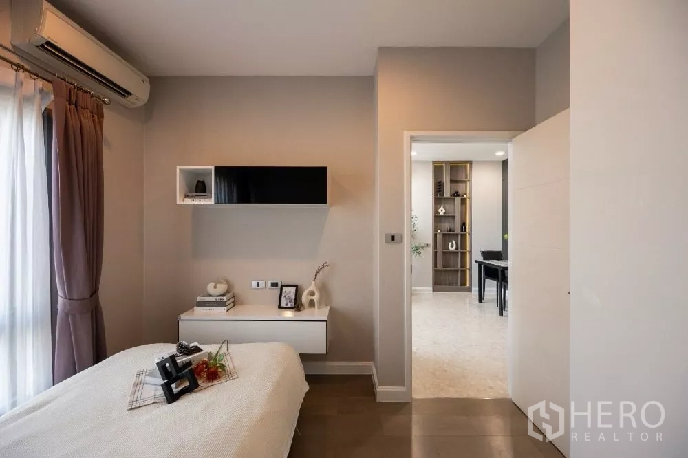 Condominium for rent or sale in Khlong Toei, Bangkok - Cozy bedroom looking toward the hallway and shelving in the adjoining room.