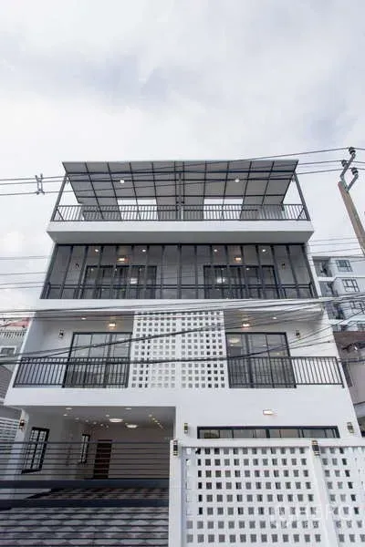 Home Office for sale in Huai Khwang, Bangkok - Modern multi-storey home office facade with large balconies and a rooftop canopy in Huai Khwang, Bangkok.
