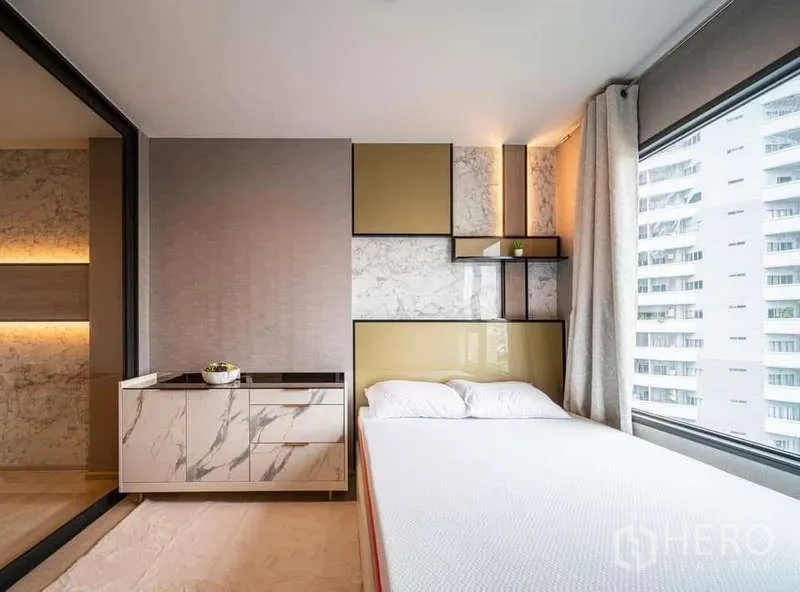 公寓 出租或出售在Pathum Wan, Bangkok - 卧室细节：大理石与金色拼接床头、斗柜与侧窗