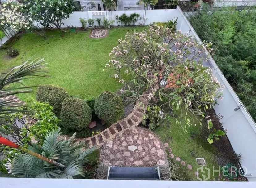 Detached House for rent in Chatuchak, Bangkok - Aerial view of the landscaped backyard with lawn, trees and stone pathway.