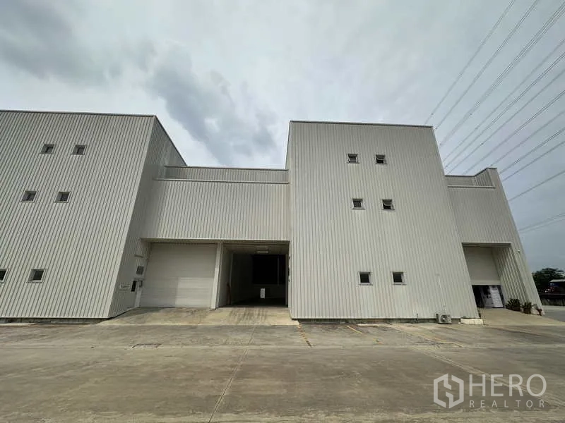 工厂 出租在Khlong Luang, Pathum Thani - 钢板外墙厂房立面，配大卷帘门与停车位