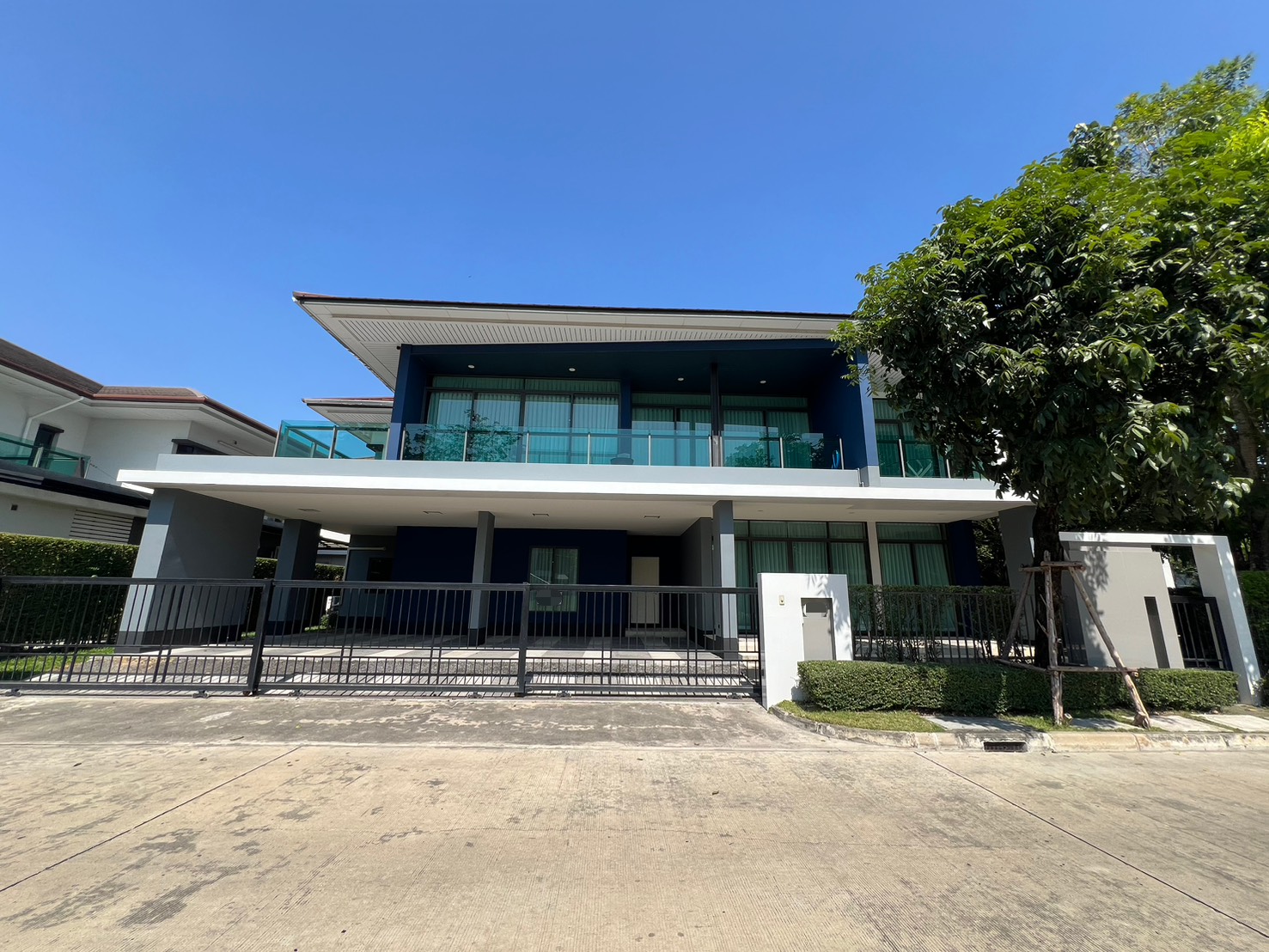 Detached House for rent in Bang Kapi, Bangkok - Modern two-storey detached house with gated driveway and a wide balcony.