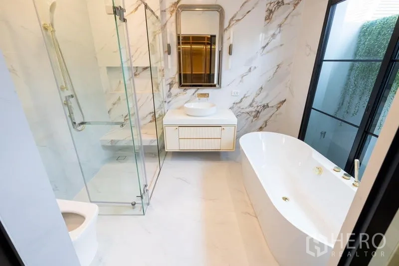 Detached House for sale in Saphan Sung, Bangkok - Luxurious bathroom with soaking tub, glass shower and marble finishes.