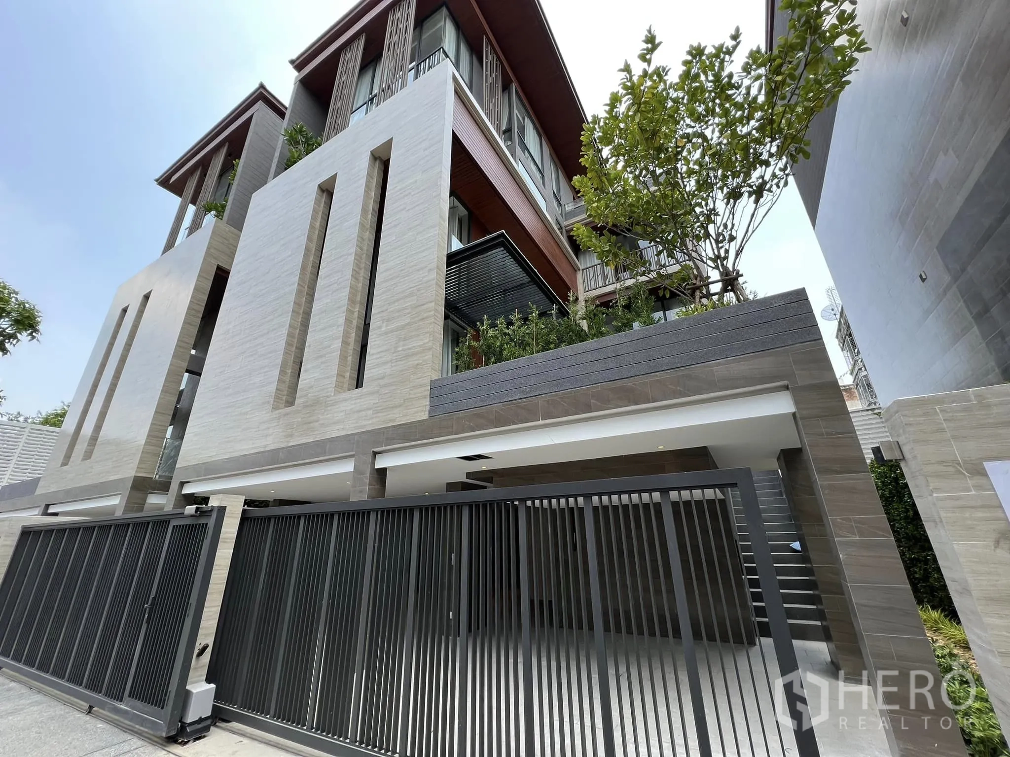 Detached House for rent or sale in Yan Nawa, Bangkok - Modern three-storey detached house facade with tall cladding and sliding gate.