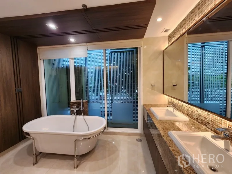 Condominium for rent in Khlong Toei, Bangkok - Master bathroom with freestanding bathtub and double-sink vanity.