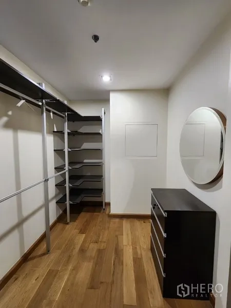 Condominium for rent in Khlong Toei, Bangkok - Walk‑in closet with open shelving and wood floors.