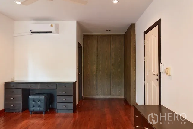 Detached House for rent in Watthana, Bangkok - Bedroom or study with built-in desk, wardrobes and wood floors.