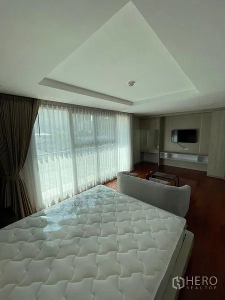 คอนโด ให้เช่าในWatthana, Bangkok - ห้องนอนมาสเตอร์กว้าง โซฟา มุมทีวี และหน้าต่างบานใหญ่พร้อมม่านโปร่ง