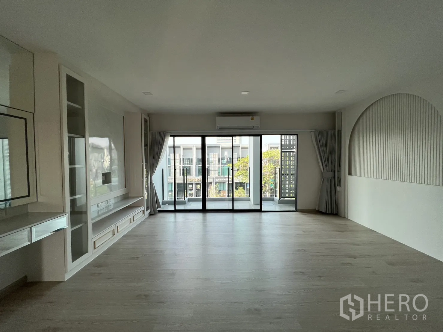 Home Office for rent in Bang Phli, Samut Prakan - Feature wall with built‑in cabinetry in a generous room opening to the balcony.