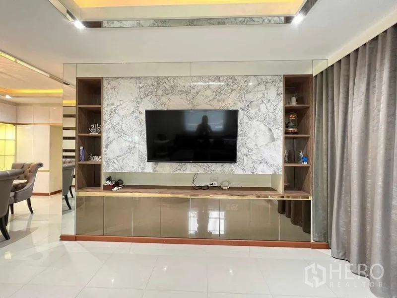Detached House for sale in Bang Kruai, Nonthaburi - Living area with marble feature wall, built-in TV cabinet, and floor-to-ceiling curtains.