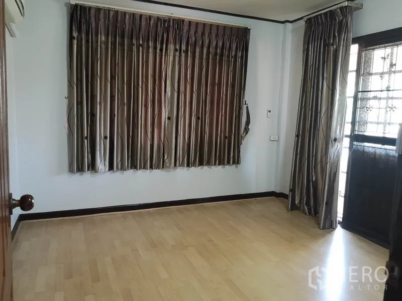 Detached House for sale - Bedroom with dark curtains, wood floors and door to a balcony.