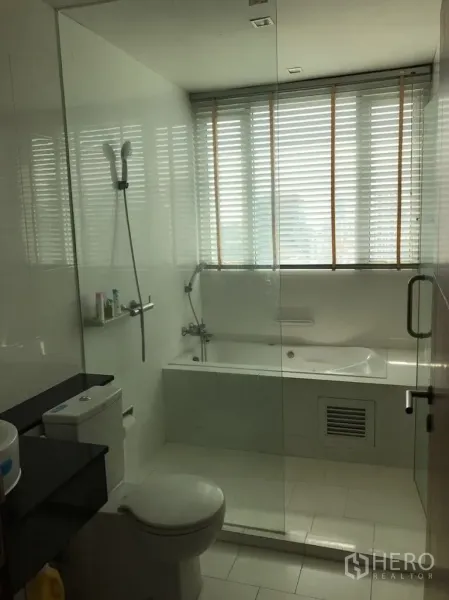 公寓 出租在Watthana, Bangkok - 现代卫浴，玻璃隔断，窗边浴缸、淋浴、坐便与洗手台。