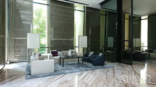 公寓 出租在Watthana, Bangkok - 挑高豪华大堂，铺设大理石地面，落地窗与舒适沙发休息区。