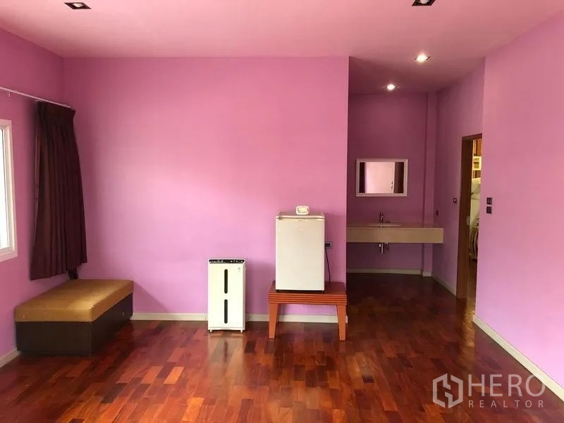 Detached House for sale in Wang Thonglang, Bangkok - Expansive pastel-toned bedroom with wood flooring and a vanity niche.