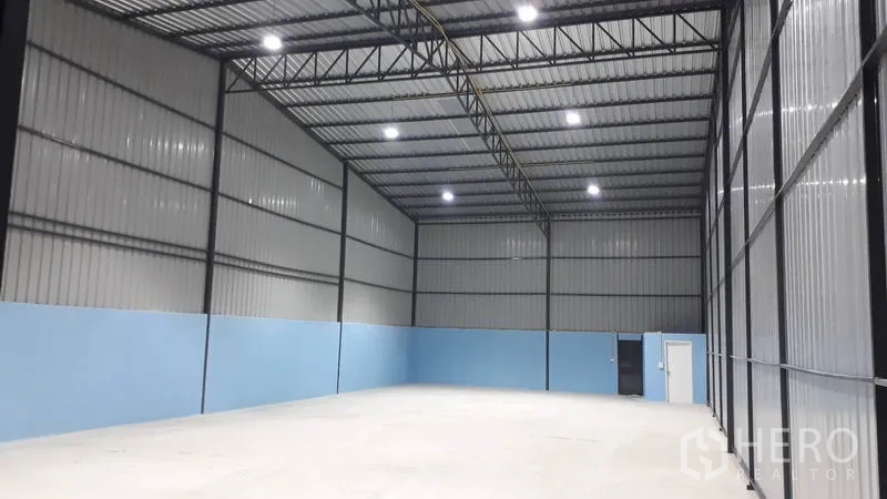 货栈 出租在Khlong Luang, Pathum Thani - 宽敞仓库内部，高天花与大型滑门，设有通往内室的出入口。
