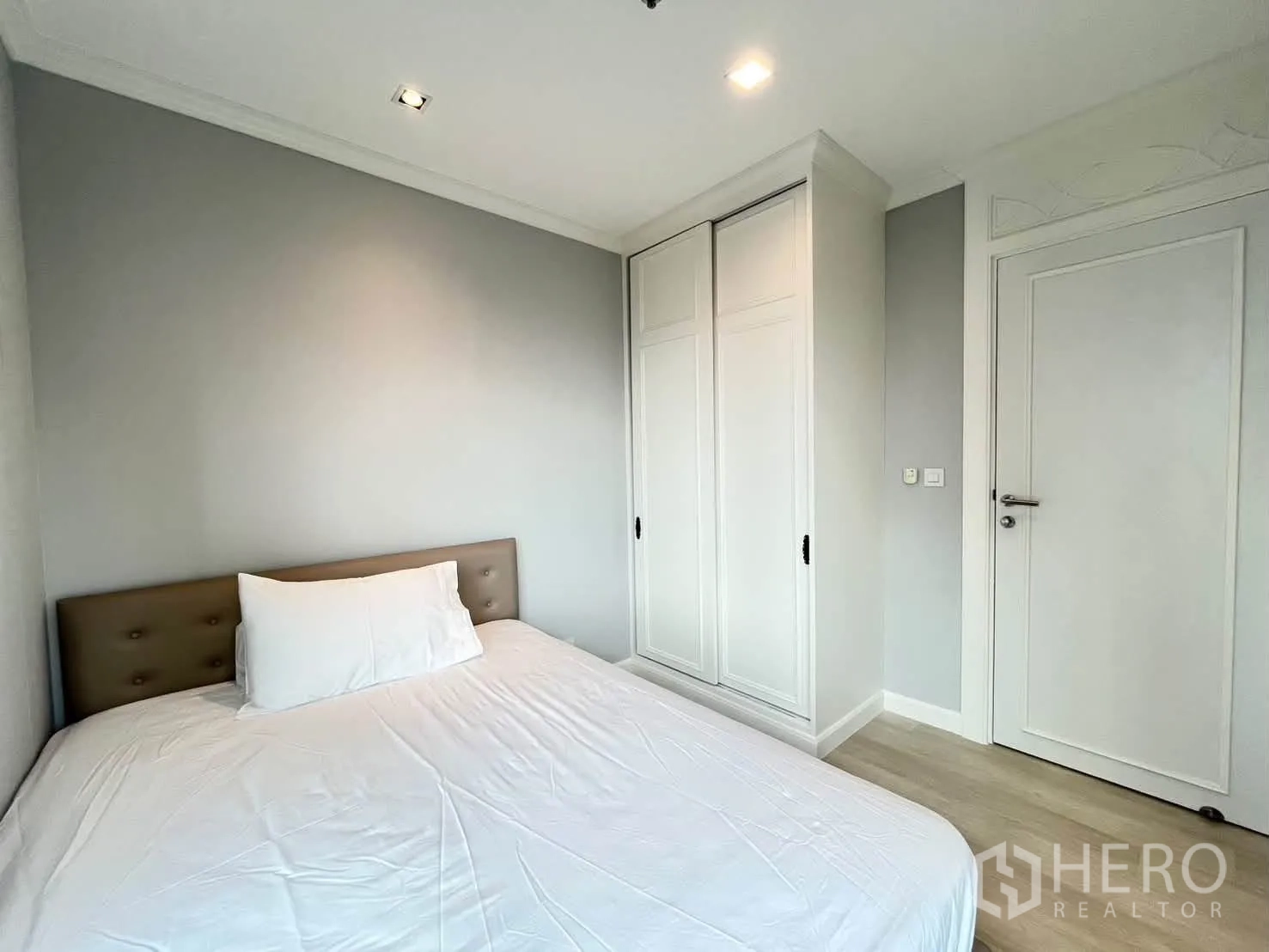 Condominium for rent in Pathum Wan, Bangkok - Compact bedroom with a double bed and built-in white wardrobe.