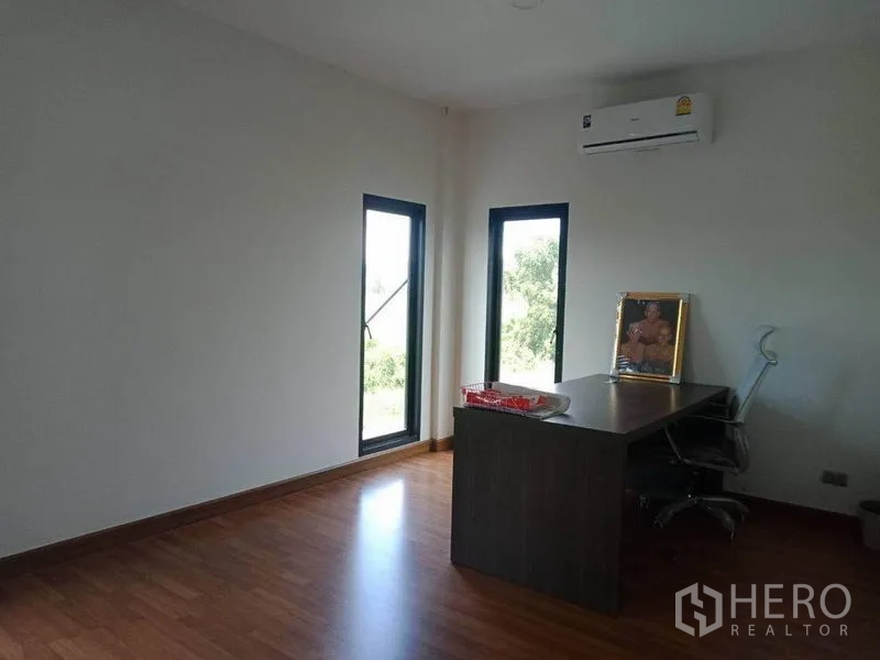 Warehouse for sale in Lam Luk Ka, Pathum Thani - Bright office room with wood flooring, tall windows and a wall-mounted air conditioner.