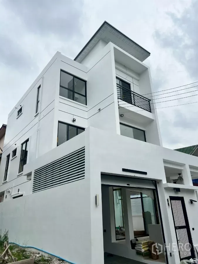 Detached House for rent in Wang Thonglang, Bangkok - Contemporary three-storey white detached house with balcony and gated entry.