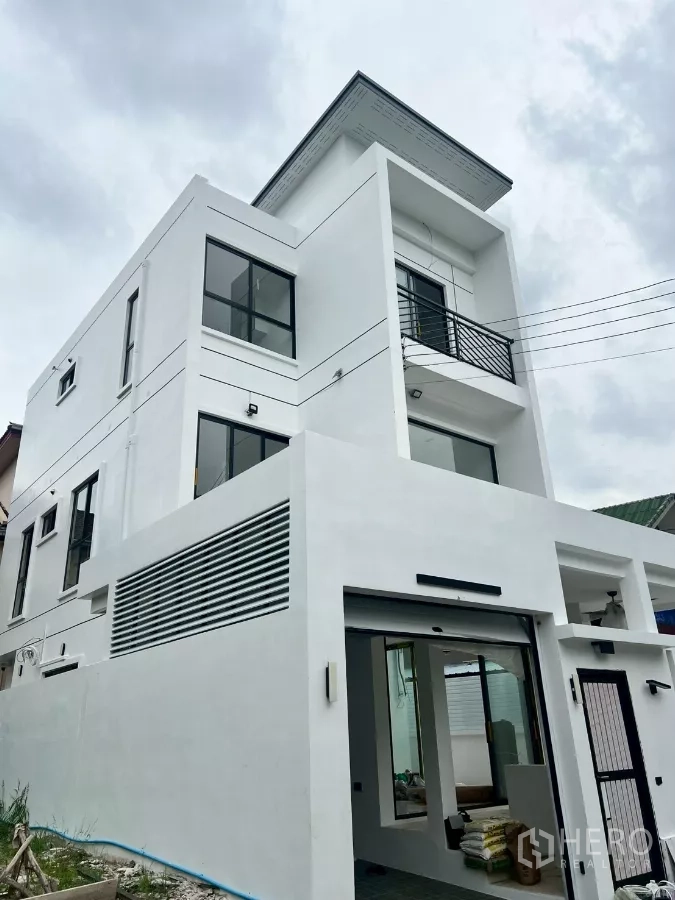 Detached House for rent in Wang Thonglang, Bangkok - Contemporary three-storey white detached house with balcony and gated entry.