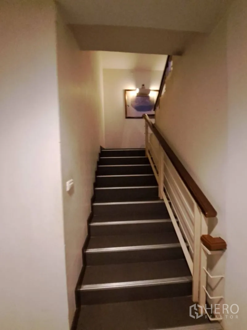Shophouse for rent in Watthana, Bangkok - Interior staircase with handrail connecting multiple floors.