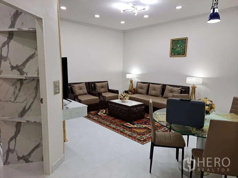 公寓 出租在Khlong Toei, Bangkok - 开放式客餐区，沙发组合、圆桌与明亮灯光。