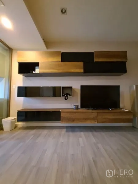 Condominium for rent in Bang Rak, Bangkok - Floating media cabinets and mounted shelves with TV on light wood flooring.