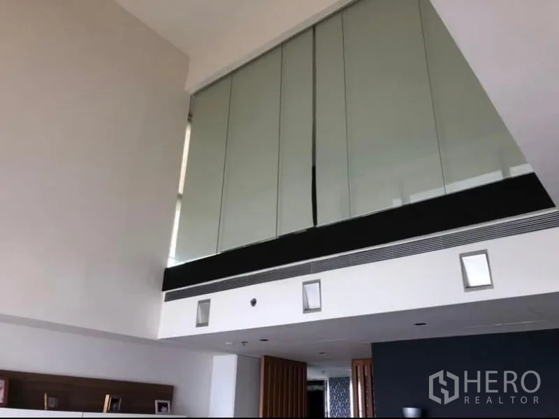 Condominium for rent in Sathon, Bangkok - Double-height ceiling with mezzanine glass wall in contemporary condo