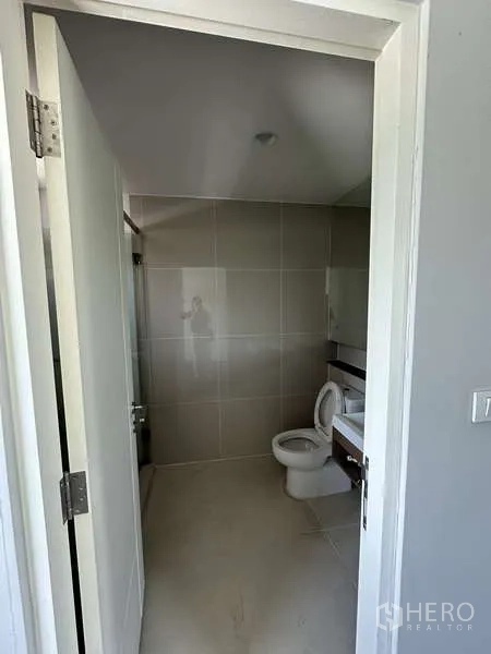 Detached House for sale in Lam Luk Ka, Pathum Thani - Powder room with sink and toilet in neutral tiles.