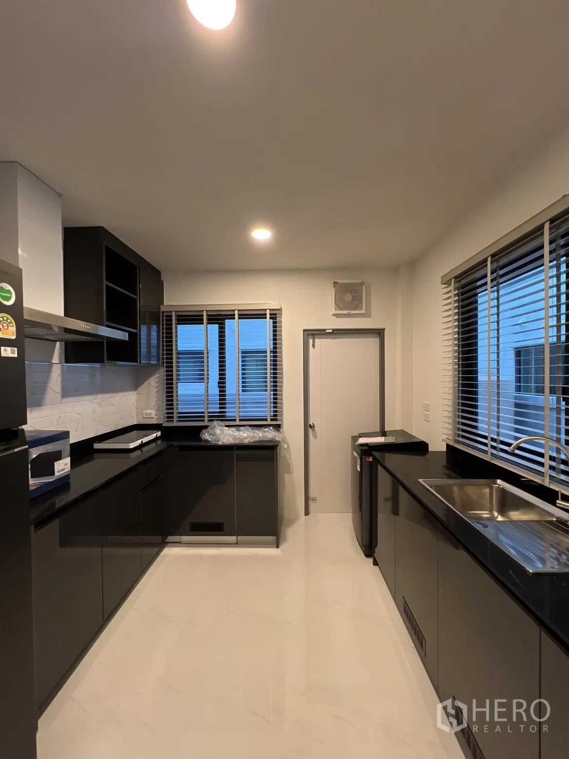 Detached House for rent in Bang Phli, Samut Prakan - Spacious kitchen with dual countertops, sink and windows for ventilation.