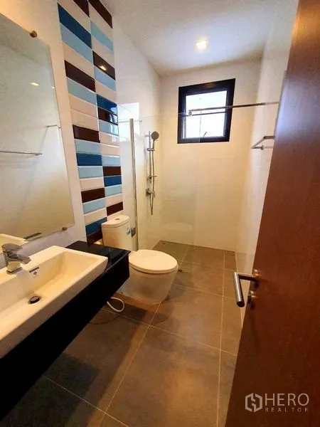 Detached House for rent or sale in Thanyaburi, Pathum Thani - Contemporary bathroom with walk-in shower, small window and colorful wall tiles.