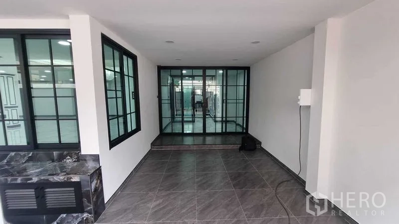 联排别墅 出租在Khlong Toei, Bangkok - 入户前厅，落地推拉玻璃门与地砖铺设。