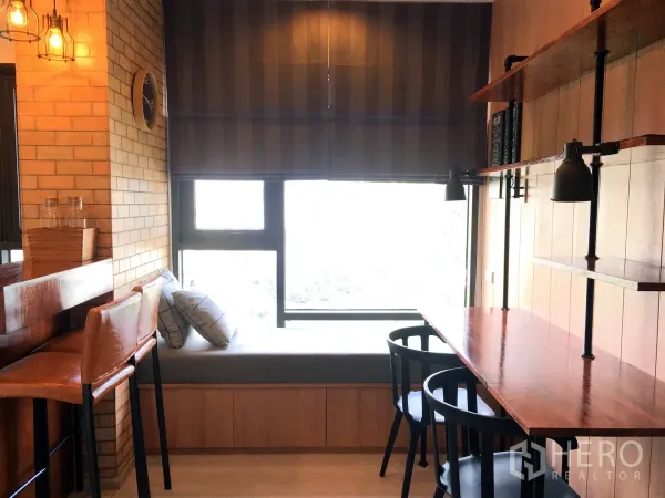 Condominium for rent in Khlong Toei, Bangkok - Window-side dining and work bar with shelves and brick feature wall in Bangkok condo