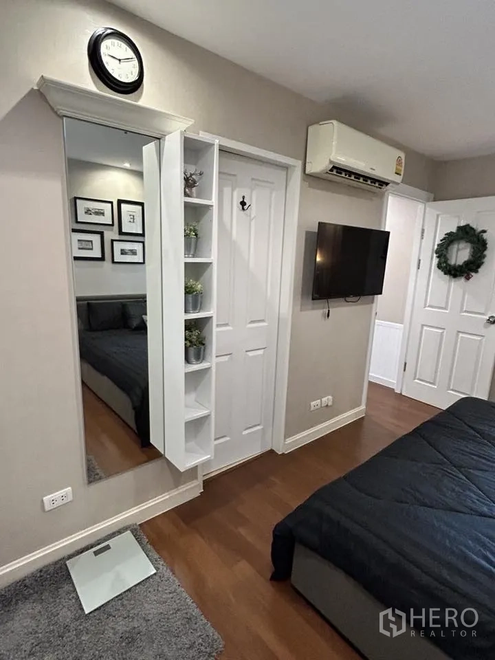 คอนโด for rent in Huai Khwang, Bangkok - ห้องนอนหลักมีทีวีติดผนัง กระจกเต็มตัว และชั้นวาง