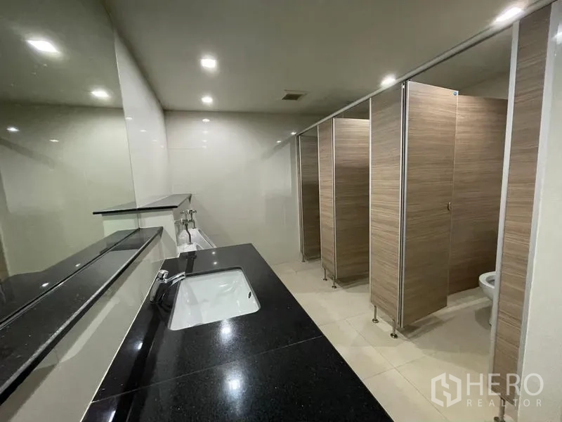 สำนักงาน ให้เช่าในRatchathewi, Bangkok - ห้องน้ำส่วนกลางทันสมัย เคาน์เตอร์หินสีดำ กระจกบานใหญ่ และห้องสุขาหลายห้อง