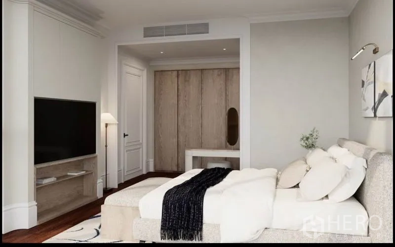 Condominium for rent or sale in Watthana, Bangkok - Guest bedroom with built-in TV, study nook and light wood accents.