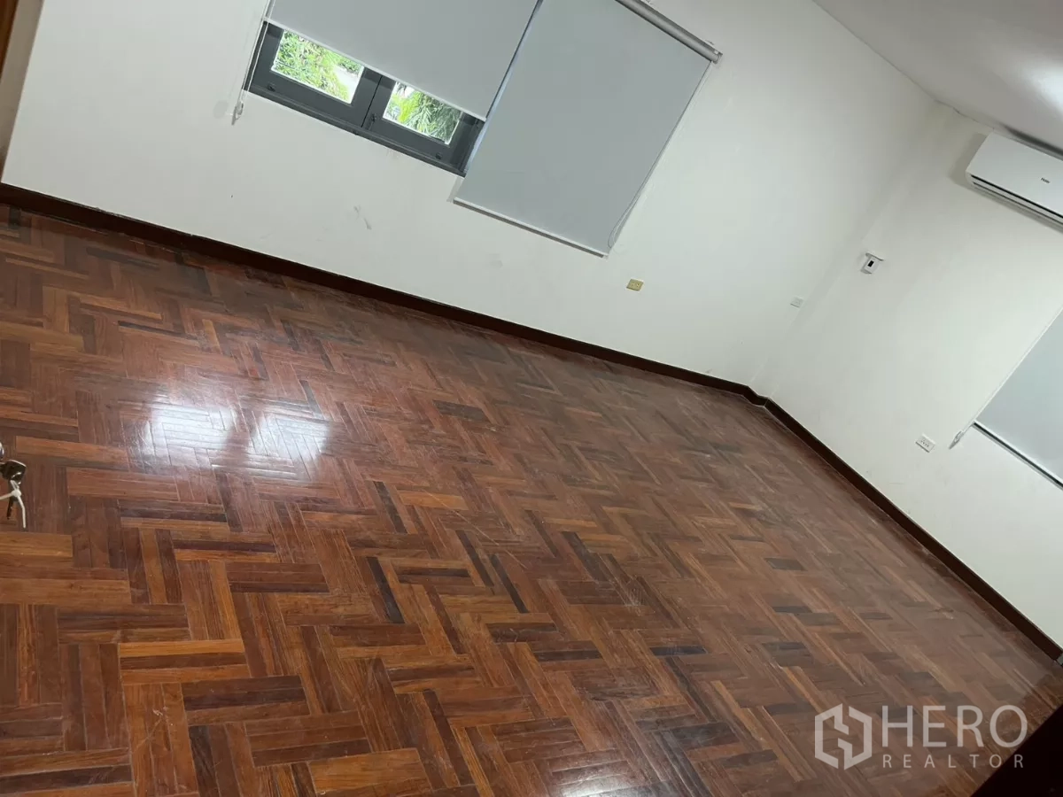 Detached House for rent in Watthana, Bangkok - Spacious bedroom with herringbone parquet flooring, air-conditioning and blinds.