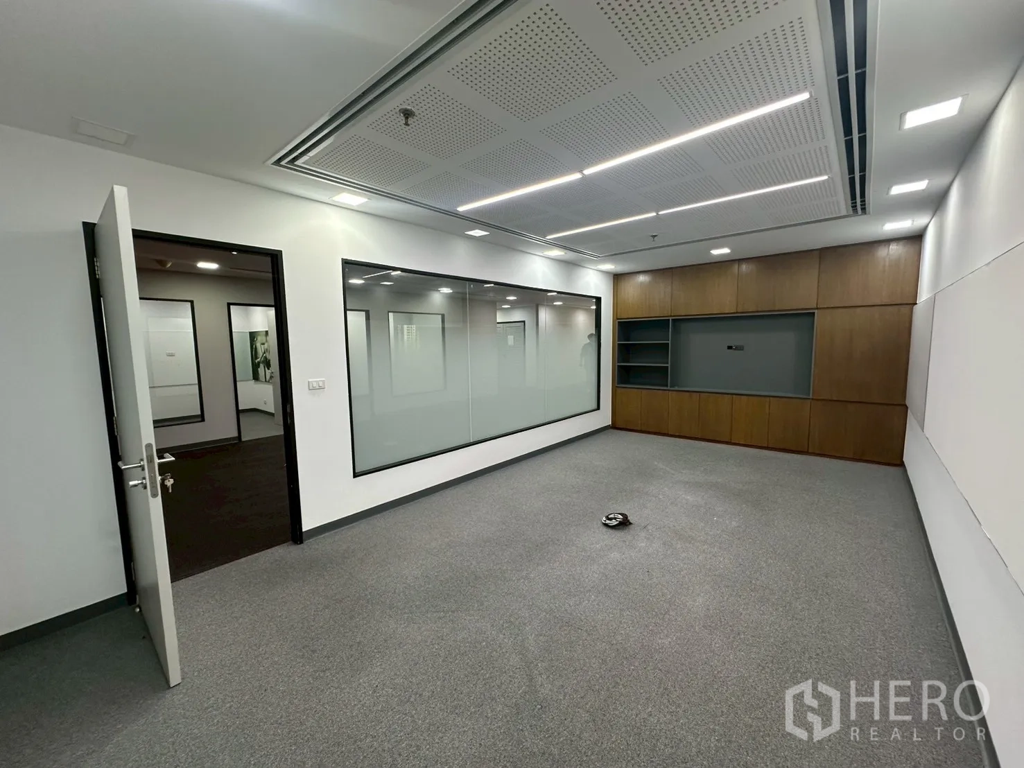 Office Space for rent - Boardroom featuring a large interior glass wall and wood cabinetry.