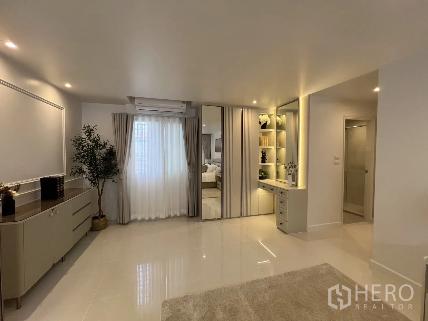 Condominium for rent in Yan Nawa, Bangkok - Dressing area with mirrored wardrobes, vanity desk, and air conditioner.