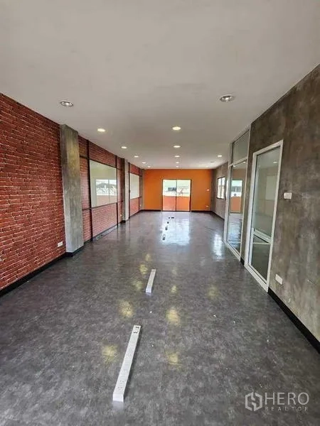 办公空间 出租或出售在Bueng Kum, Bangkok - 开放式办公楼层，裸砖墙面、亮面地板、筒灯照明，尽头为玻璃隔间。