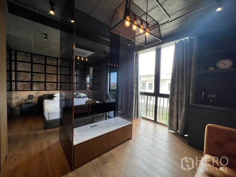 Townhouse for rent in Saphan Sung, Bangkok - Master suite with glass partition, pendant lights, and large windows over wood flooring.