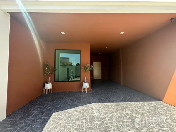 Home Office for rent in Wang Thonglang, Bangkok - Covered carport and entrance with terracotta walls, tiled floor, and potted plants.