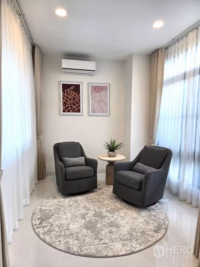 独立式住宅 出租在Saphan Sung, Bangkok - 温馨会客角，两把扶手椅与圆形地毯临窗而设。