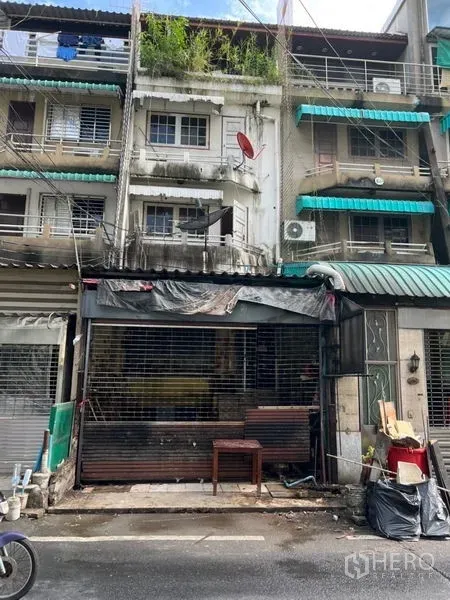 店屋 出租在Watthana, Bangkok - 四层店屋外立面，金属卷闸门与阳台，位于曼谷素坤逸商圈。